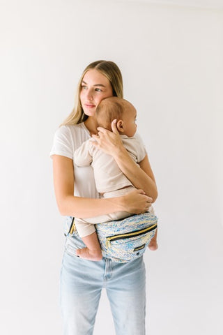 Parent holding baby in a face-to-face position using a Tushbaby Hip Carrier, promoting bonding and support.