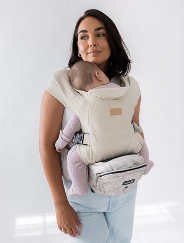 Parent wearing baby in an inward-facing position using the Tushbaby Hip Carrier with The Hip Seat Hands-Free Attachment, showing secure and comfortable support.